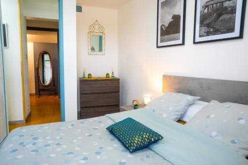 1 dormitorio con cama azul y almohada azul en 100 m2 de charme vue sur la Loire, en Saint-Clément-des-Levées