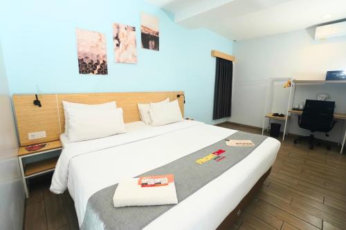 a hotel room with a large bed and a desk at Front One Hotel Pasir Koja Bandung in Bandung