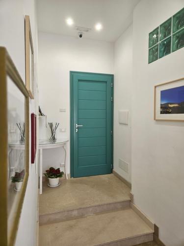 una puerta verde en un pasillo con una mesa en B&B Mormina, en Scicli