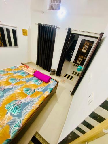 Nirupam Sadan HomeStay في فريندافان: غرفة نوم مع سرير مع لحاف ملون
