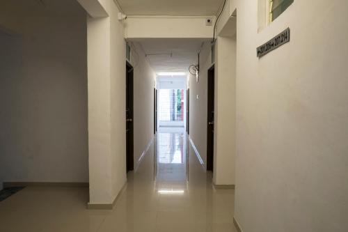 un corridoio con pareti bianche e un corridoio che conduce a una porta di RVC Hospitality Near Pune Airport a Kharadi