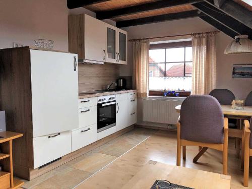 a kitchen with a white refrigerator and a table at Haus Margret in Carolinensiel