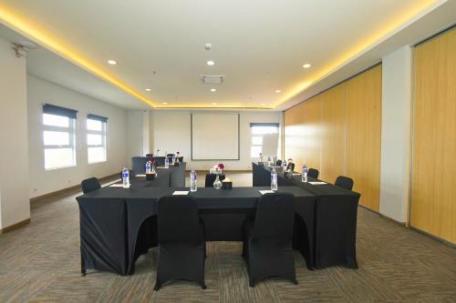 a conference room with a black table and chairs at Front One Hotel Pasir Koja Bandung in Bandung