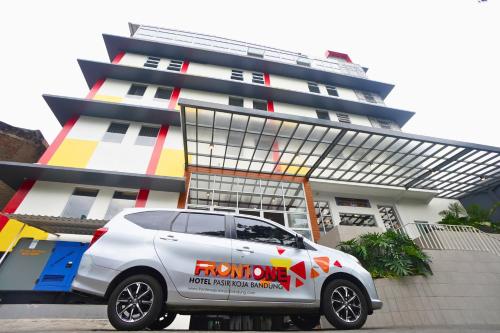 a white car parked in front of a building at Front One Hotel Pasir Koja Bandung in Bandung