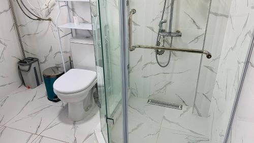 a bathroom with a toilet and a glass shower at Guest house Roza in Kazarman