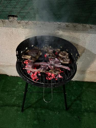 - un grill avec de la viande et d'autres aliments dans l'établissement Apartamento bajo con terraza y piscina, à Torrevieja
