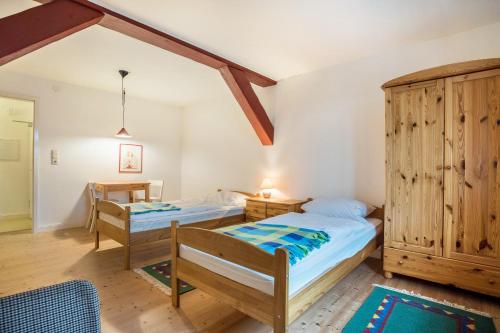 - une chambre avec 2 lits et une armoire en bois dans l'établissement Wohnung Kemenate, à Trendelburg