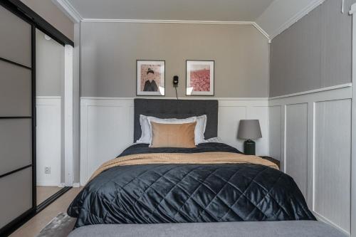 - une chambre avec un grand lit et une couverture noire dans l'établissement Guestly Homes - Central Charm, à Boden