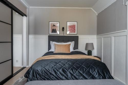 a bedroom with a large bed with a black blanket at Guestly Homes - 2BR Central Charm in Boden