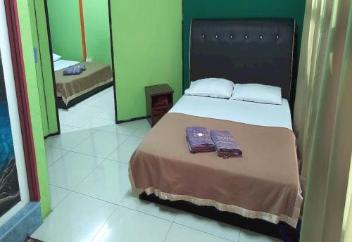 a bedroom with a bed with two towels on it at OYO 90937 Tanjak Hotel in Alor Setar
