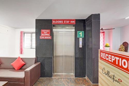 un vestíbulo con ascensor con una señal de que los lectores se quedan en la posada en Super Capital O Blooms Stay Inn Near Snow City, en Bangalore
