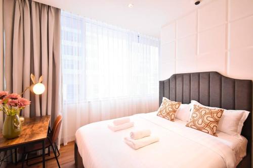 a bedroom with a large bed with a desk and a window at Heart of DIFC: SKY Gardens Modern Chic Studio in Dubai