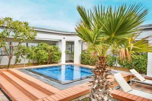 a swimming pool in a backyard with a palm tree at Heart of DIFC: SKY Gardens Modern Chic Studio in Dubai