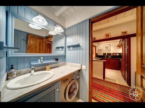een badkamer met een wastafel en een wasmachine bij TESO DERA MINA de Alma de Nieve in Tredós