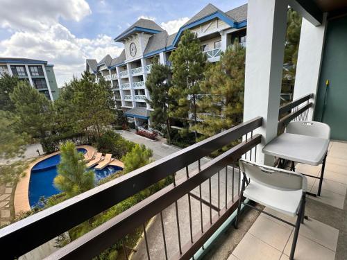 a balcony with chairs and a view of a hotel at CozyVilla at Pine Suites Tagaytay 2BR or Studio with FREE PARKING in Tagaytay