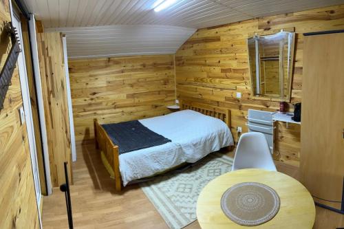 ein Schlafzimmer mit einem Bett und einem Tisch in einem Zimmer in der Unterkunft Gîte : La Petite Grange in Valojoulx