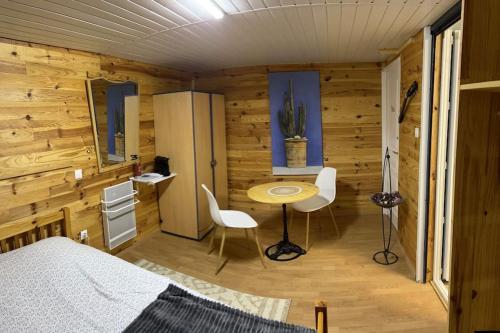 une chambre avec un lit, une table et des chaises dans l'établissement Gîte : La Petite Grange, à Valojoulx