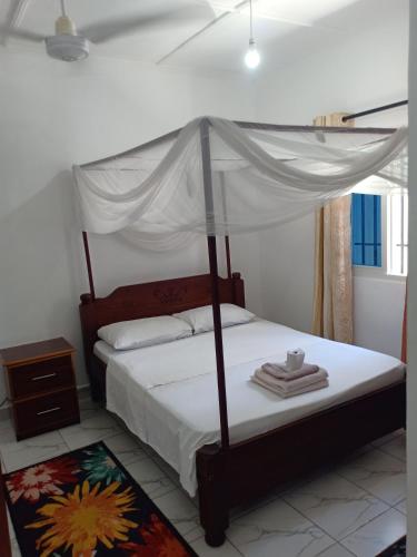 - une chambre avec un lit à baldaquin dans l'établissement Anna Mtwapa Luxury Apartments, à Mtwapa