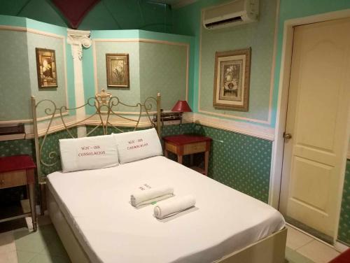 1 dormitorio con 1 cama con 2 toallas en WJV INN CABANCALAN en Mandaue City