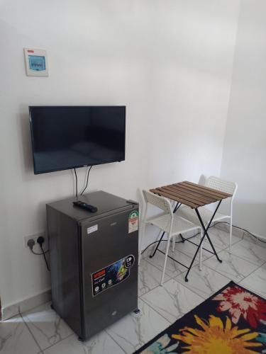 Elle comprend un réfrigérateur et une télévision à écran plat. dans l'établissement Anna Mtwapa Luxury Apartments, à Mtwapa