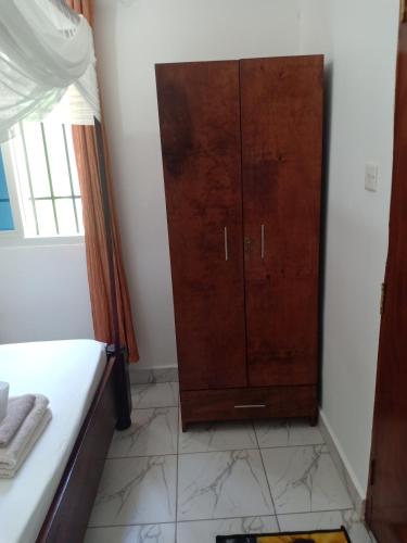 - une chambre avec une armoire en bois dans l'établissement Anna Mtwapa Luxury Apartments, à Mtwapa