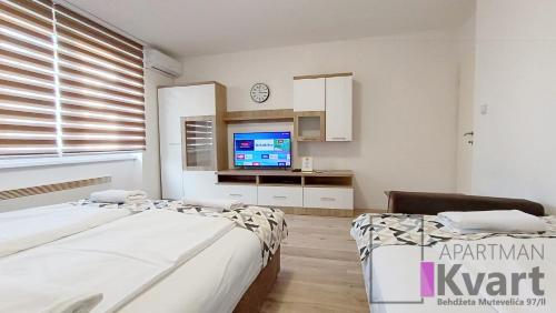 a bedroom with two beds and a tv in it at Apartman Kvart in Sarajevo