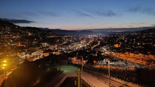 a view of a city at night with lights at Apartman Kvart in Sarajevo