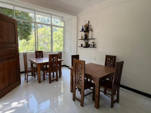 uma sala de jantar com uma mesa e cadeiras e uma janela em Kai Kazee Ella em Ella