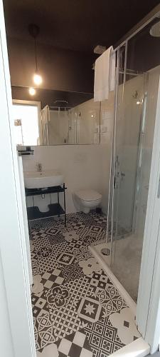 a bathroom with a shower and a sink and a toilet at Hotel Villa Rina in Riva del Garda