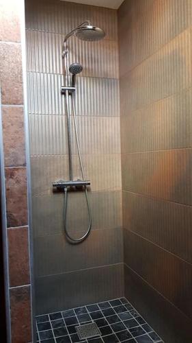 une douche avec pommeau de douche dans une salle de bain dans l'établissement La Gloriette des Eglantines, à Saint-Gervais-la-Forêt