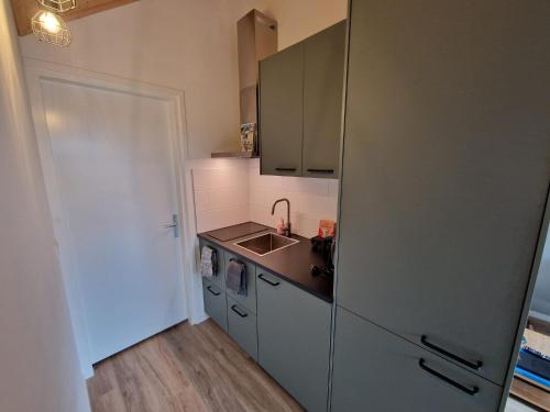 uma cozinha com um frigorífico de aço inoxidável e um lavatório em Zoetenaar Zoutelande em Zoutelande