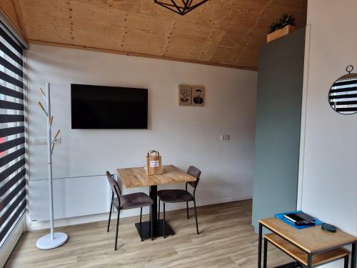 een eetkamer met een tafel en stoelen en een tv bij Zoetenaar Zoutelande in Zoutelande