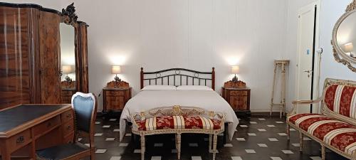 een slaapkamer met een bed, 2 stoelen en een dressoir bij Residenza Donnafugata B&B in Ragusa