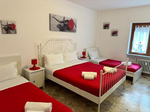 1 Schlafzimmer mit 2 Betten und roter Bettwäsche in der Unterkunft Apartment Sant'Antonio in Bari