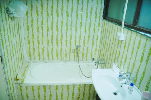 een badkamer met een wastafel, een spiegel en een bad bij Hostell One - A complete backpacker & Coworking Hub in Pune
