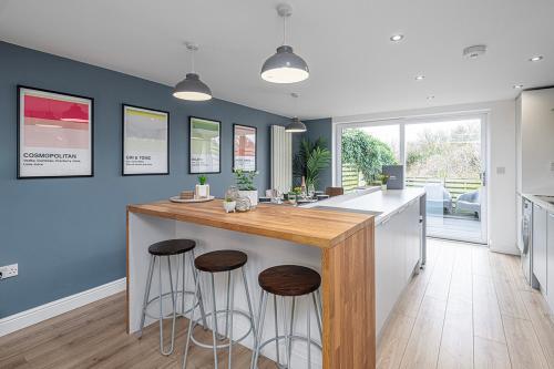a kitchen with a large island with bar stools at 3 BED-EN-SUITE-PRIVATE-PARKING- Near RHOSNEIGR in Rhosneigr