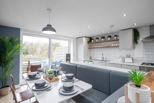 a dining room with a table and a kitchen at 3 BED-EN-SUITE-PRIVATE-PARKING- Near RHOSNEIGR in Rhosneigr