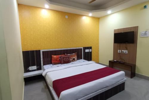 a bedroom with a large bed and a flat screen tv at Goroomgo Sashi Near Golden Beach Puri - Excellent Service in Puri