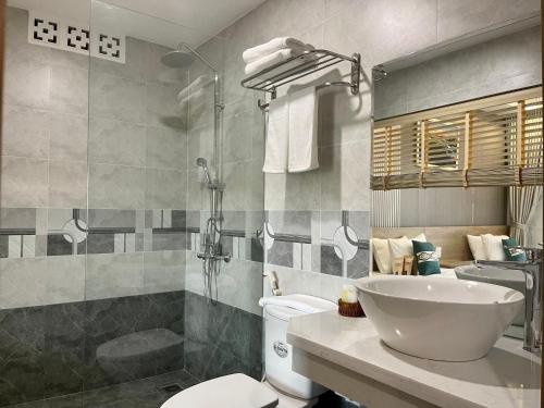 ein Bad mit einem Waschbecken, einem WC und einer Dusche in der Unterkunft Khoa Hotel Phan Thiết in Ấp Bình Hưng