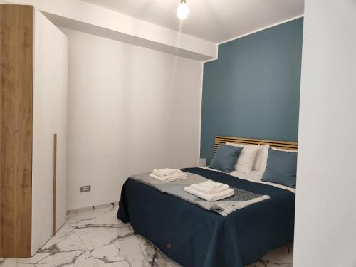 Un dormitorio con una cama azul con toallas. en A Casa Mia 2.0, en Saronno