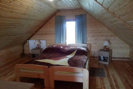 a bedroom in a log cabin with a bed and a window at Domek in Smołdziński Las