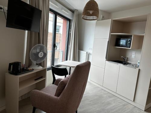 een woonkamer met een tafel en 2 stoelen en een keuken bij Twenty Business Flats Lille - Bayard in Lille
