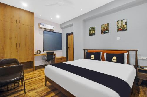 a bedroom with a bed and a desk and a tv at Townhouse Hitec City Near Image Hospital in Hyderabad