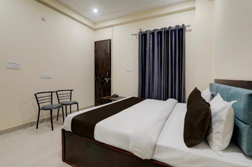 a bedroom with a large bed and a chair at FabHotel JP International in Lucknow