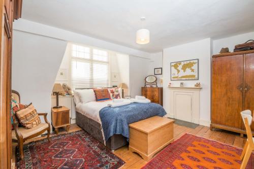 sypialnia z łóżkiem, krzesłem i oknem w obiekcie Tranquil Oasis by Pop Brixton by UndertheDoormat w Londynie
