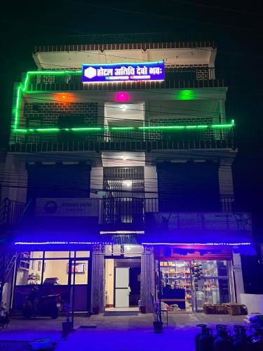 a building with green and blue lights on it at Hotel Atithi Devo Bhava in Lālbhitti