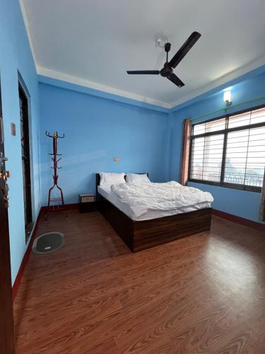 a bedroom with a bed and a ceiling fan at Hotel Atithi Devo Bhava in Lālbhitti
