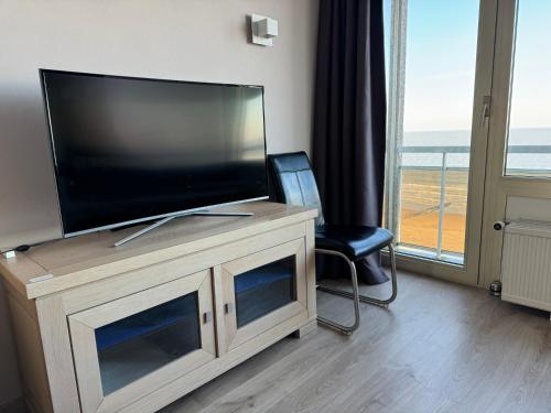 a flat screen tv sitting on top of a entertainment center at Luxe seaview appartment in Blankenberge