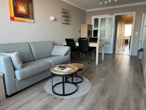 a living room with a couch and a table at Luxe seaview appartment in Blankenberge
