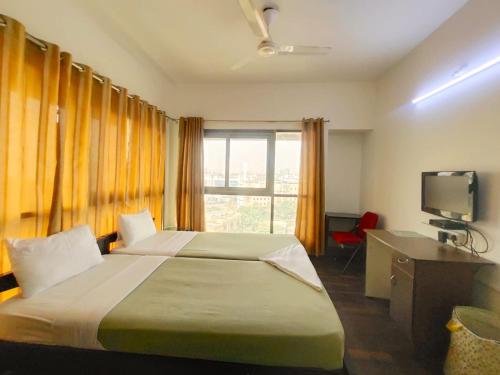a hotel room with a bed and a television at Private room in Blueridge in Hinjewadi